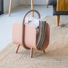 a magazine rack sitting on top of a rug in a living room