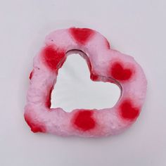 a heart shaped candy with red dots on it