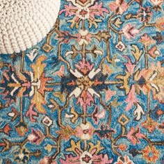 a close up view of a colorful rug with a crochet hat on top