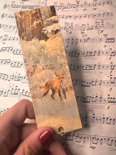 a bookmark with an image of a fox on it and music sheets in the background