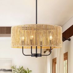 a chandelier hanging from the ceiling in a living room with white walls and curtains