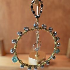 a metal object with beads and chains hanging from it's center ring on a table