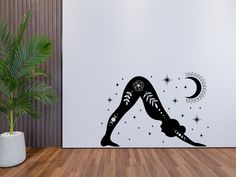 a woman doing yoga in front of a wall with stars and crescents on it