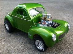 a green toy car with an engine on the hood