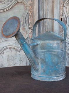 an old metal watering can with a wooden spoon