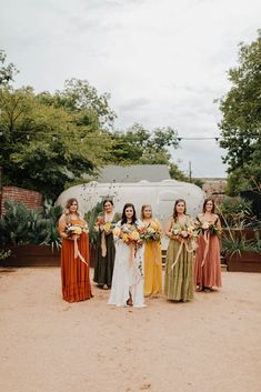 a group of women standing next to each other in front of a van with flowers