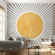 a living room filled with furniture and a large sunburst painting on the wall