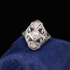 Gorgeous Antique Art Deco 18K White Gold Diamond and Sapphire Shield Ring. This beautiful art deco shield ring features amazing old european cut diamonds and sapphires on a filigree white gold art deco ring. Item #R0622Metal: 18K White GoldDiamond: Approximately .30 ctsColor: HClarity: SI1Weight: 3.1 GramsRing Size: 3Measurements: 16.9 mm wideLayaway: For your convenience, we will be happy to provide layaway payment options. Please contact us to work out a layaway plan which best suits your need Gold Art Deco Ring, Emerald Ring Engagement Diamond, Wedding Band Engraving, Shield Ring, Diamond Cluster Engagement Ring, Art Deco Diamond Rings, Antique Diamond Rings, Art Deco Glass, Gold Art Deco