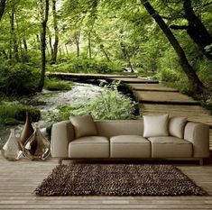 a couch sitting on top of a wooden floor next to a forest filled with trees