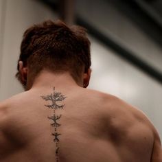 the back of a man with tattoos on his upper and lower part of his body