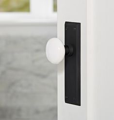 a white door handle with a black and white knob on the outside of a building