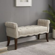 a white bench sitting on top of a carpeted floor next to a potted plant