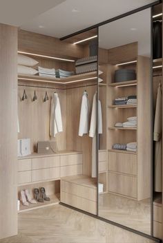 a walk in closet with mirrored doors and shelves filled with clothing, shoes and other items