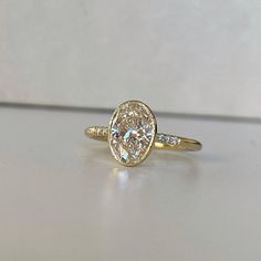 a yellow gold ring with an oval cut diamond