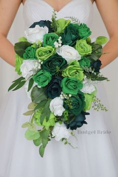 a bride holding a green and white bouquet