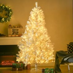 a white christmas tree in front of a fireplace