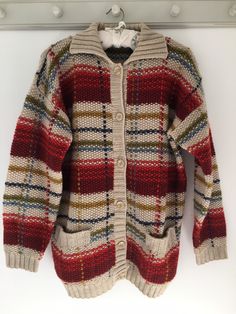 "Vintage cardigan, heavy knit, 90's clothing, chunky cardigan, wool knit, ladies cardigan, 90's cardigan, oversized, coatigan, multi coloured Gorgeous knitted  cardigan. Lovely heavy, chunky knit, wool cardigan in reds, beige, green, ochre and blues.  Very well made with ribbed collar, long tunic style and button fastening. Two pockets. In lovely preloved vintage condition.  Coatigan style cardigan/coat. Beautiful vintage design No labels. But quite large - please check measurements. 100% wool. Oatmeal Cardigan, Ladies Cardigan, Ivory Cardigan, Cardigan Oversized, Chunky Cardigan, Heavy Knit, Vintage Cardigan, Tunic Style, Style Cardigan