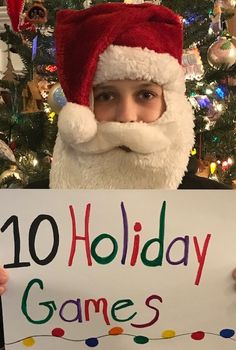 a man dressed as santa clause holding up a sign that says 10 holiday games on it