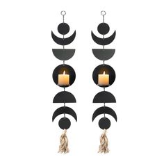 two black metal wall hangings with candles in them