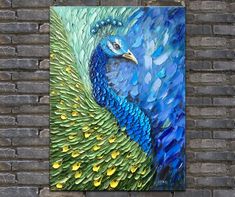 a painting of a peacock on a brick wall