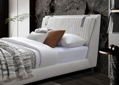 a white bed with pillows and blankets on it