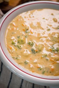 a white bowl filled with broccoli and cheese soup