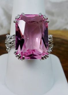 This is a brand new Victorian/Art Nouveau inspired in solid sterling silver. The gorgeous filigree ring is set with a 13ct Man-made/Simulated pink topaz. The rectangular cushion-cut gem is 18mm (just shy of 3/4th of an inch) by 13mm (1/2 inch) in size. The inside of the band is marked 925 for solid sterling. Notice the intricate and detailed leaf floral design of the silver filigree setting. A giftbox is included for safe keeping. Feel free to ask questions and thanks for looking at my listings. Pink Topaz Center Stone Ring In Sterling Silver, Pink Amethyst Ring In Sterling Silver For Formal Occasions, Pink Topaz Ring With Accent Stones In Sterling Silver, Pink Gemstones In Sterling Silver Fine Jewelry, Pink Sterling Silver Gemstones For Anniversary, Silver Emerald Cut Gemstones With Accent Stones, Hallmarked Emerald Cut Topaz Ring In Sterling Silver, Sterling Silver Solitaire Gemstones For Anniversary, Pink Gemstone Ring