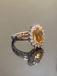 DeKara Designs Classic Metal- 14K Yellow Gold, .583. Stones- 1 Oval Imperial Topaz 3.50 Carats, 16 Round Diamonds G Color VS1 Clarity 0.55 Carats. Size- Choose Your Size, from 4-12. Please allow three to five working days for me to ship out your ring. I will start on making your ring as soon as transaction has been processed. Classic 14K yellow gold Art Deco influenced halo Imperial Topaz diamond engagement ring. The center stone is a whopping prong set 3.15 fiery oval shaped Peach colored beaut Luxury Yellow Gemstones For Wedding, Luxury Halo Setting Gemstones For Wedding, Cluster Diamond Gemstones For Wedding, Luxury Yellow Sapphire Ring With Center Stone, Luxury Gemstones With Halo Setting For Wedding, Formal Cluster Gemstone Halo Ring, Cluster Gemstone Halo Ring For Formal Occasions, Formal Cluster Halo Ring With Gemstones, Luxury Yellow Gold Topaz Ring With Brilliant Cut