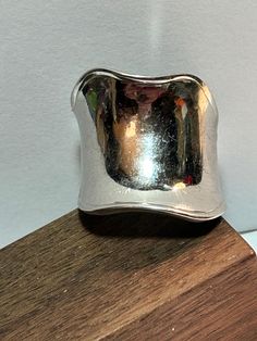 "This is a beautiful, vintage Charles Garnier polished sterling silver wavy saddle ring. The ring is a size 7 and could easily be resized by a jeweler if needed smaller or larger.  The ring face measures nearly 7/8\" at the widest point then 1/2\" to 1/4\" in width at other spots. Very well-made ring that has a modernist feel to the design. The ring weighs about 11.7 grams and is stamped with the Charles Garnier logo - the C and G separated with the spade - and 925 Peru.  Very pretty. See pictures for details. More gorgeous jewelry here, and some on BIG clearance in my shop:  https://bargainbitz.etsy.com Please note: The display model is not human size and is just meant to show the details of the piece. Please refer to the exact measurements in the listing for size." Vintage Sterling Silver 925 Wide Band Ring, Vintage Silver Wide Band Ring, Silver Wide Band Rings For Collectors, Vintage Silver Concave Jewelry, Vintage Wide Band Jewelry Stamped 925, Vintage Wide Band Sterling Silver Ring, Vintage Silver Wide Band Ring Stamped 925, Vintage Silver Wide Band Jewelry, Vintage Sterling Silver Wide Band Ring Gift