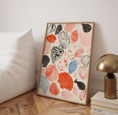 an art print is displayed on the floor next to a lamp