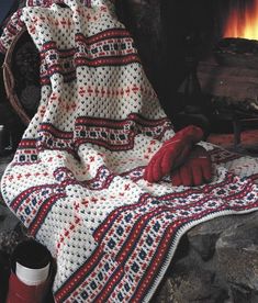 a crocheted blanket sitting on top of a fire place