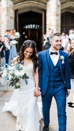 a bride and groom walking down the street