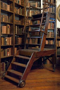 an old wooden staircase in front of a bookshelf