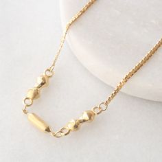 This unique necklace features gold beads and cylinders in the middle, connected with bismark chain link all in luxurious . Meticulously crafted, this eye-catching necklace is perfect to wear fo all occasions; either alone, or layered with other chains and necklaces! Metal: solid 18k yellow gold (not gold plated, not gold filled) Thickness: 2 mm chain + 4 mm beads Length: 16 inches Weight: 8.5 grams Closure: Spring Ring Please allow up to 5 business days for processing. Currently only shipping within Canada and the USA. | c u r a t e d | Visit our website for curated and modern pieces  https://www.menkduke.com | f a c e b o o k | Follow us on Facebook for new item announcements and discounts  https://www.facebook.com/menkDUKE/ | i n s t a g r a m | Follow us on instagram to see what we're u Sparkly Necklace, Vintage Beads Necklace, Gold Bead Necklace, Bridal Gift, Unique Necklace, Wedding Jewellery Necklace, Metal Necklaces, Bridal Gifts, Unique Necklaces