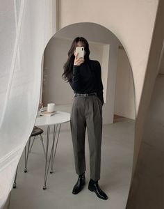 a woman taking a selfie in front of a white backdrop with a round mirror