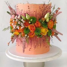 an orange and pink cake with flowers on top