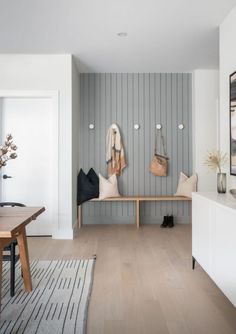 a living room filled with furniture next to a wooden table and white walls on the wall