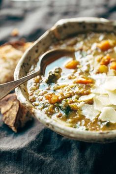 a close up of a bowl of soup on a cloth with a spoon in it