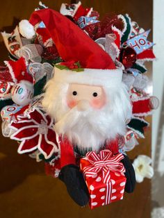 a christmas wreath with a santa claus doll hanging from it