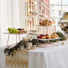 three tiered trays filled with food on top of a table next to a window