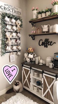 a coffee bar with shelves and cups on the wall above it that has a pink heart shaped sticker