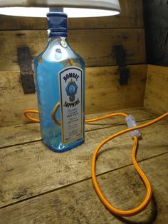 a blue bottle sitting on top of a wooden table next to a white light bulb