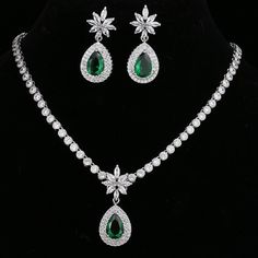 Make a stunning statement with this exquisite jewelry set, featuring a captivating emerald green cubic zircon necklace and earrings. Whether you're attending a wedding, a special event, or simply want to add a touch of sophistication to your ensemble, this set is the perfect choice. Key Features: Designed for the trend-conscious individual Elegant geometric shape and pattern Suitable for weddings and other special occasions Made of high-quality copper and adorned with shimmering cubic zirconia I Formal Green Bridal Necklace With Sparkling Stones, Green Crystal Jewelry Sets With Sparkling Stones, Green Jewels Jewelry Sets For Anniversary, Green Jeweled Jewelry Sets For Anniversary, Green Sparkling Stones Jewelry Sets For Wedding, Green Jeweled Anniversary Jewelry Sets, Formal Emerald Jewelry Sets With Jewels, Formal Green Cubic Zirconia Emerald Necklace, Green Cubic Zirconia Jewelry Set With Jewels