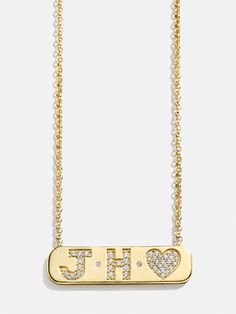 Create your own keepsake with the 18K Gold Initial Bar Necklace. Add 2 letters to this gold bar pendant featuring a crystal heart at the end. Fitted with Cubic Zirconia stones on the letters and heart, it adds the perfect pop of shine to any necklace stack. Add your initials, those of you and a loved one, or those of you and your family. Better yet, this piece is crafted with 18K gold plated sterling silver, making it perfect for everyday wear. Please note: The heart symbol will be automatically Initial Bar Necklace, Gold Bar Pendant, Bauble Bar, Necklace Stack, Preppy Jewelry, Heart Symbol, Gold Bar Necklace, Gold Initial, Bar Pendant