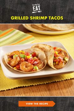 two shrimp tacos on a white plate