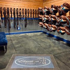 there is a blue bench in the middle of a room with many hats on it