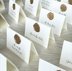 many different types of waxed seals on white cards and envelopes with gold foil