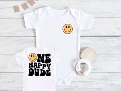 One Happy Dude Baby Bodysuit, Smiley Face First Birthday, First Birthday Outfit, Baby Birthday Outfit, First Birthday Shirt, Baby Bodysuit 💗  Welcome to The WildflowerbyMiley Etsy Shop!  This listing is for the bodysuit, sweatshirt or t-shirt only. All other items that are shown in our photos such as shoes, hats, beanies, blankets etc. are for photo staging purposes and are NOT INCLUDED in the sale. DESCRIPTION:  This baby and children's unisex essential fits like a well-loved favorite. Super soft t-shirts, sweatshirts and baby bodysuits for your little lads and gals meant to showcase their big personalities. Its Excellent quality and vibrant print makes one fall in love with it over and over again.  This adorable piece is the perfect lightweight layer for casual wearing.  This product is Cute Unisex Bodysuit For Birthday, Playful Short Sleeve Bodysuit For Birthday, Playful Unisex Onesie For Birthday, Smiley Face First Birthday, Baby Birthday Outfit, One Happy Dude, First Birthday Shirt, First Birthday Outfit, First Birthday Shirts