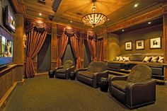 a home theater with leather chairs and curtains