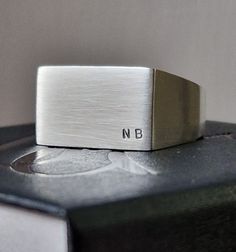 This simple yet classic rectangle signet ring can be personalised with initials of your choice, made from solid sterling silver, it is a thoughtful gift for any celebration. ---------------------------------------------------------------------------------- Each item is individually handmade, hand stamped and finished in my workshop. The personalisation is hand stamped rather than machine engraved, as such, any irregularities should be appreciated as part of a bespoke design. -------------------- Classic Rectangular Signet Ring With Initials, Minimalist Engraved Ring With Engraving Option, Classic Rings With Brushed Finish As Gift, Classic Ring With Brushed Finish For Gift, Classic Ring With Brushed Finish As A Gift, Minimalist Brushed Finish Promise Ring, Modern Signet Ring With Engraving Option For Gift, Minimalist Initials Rings For Formal Occasions, Minimalist Initial Ring With Engraving Option